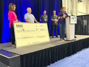  Danielle Forbes of National Service Dogs accepts a $50,000 check from RAWZ Natural Pet Food owners, Janet and Jim Scott at the Pets Canada Industry Show in Toronto.