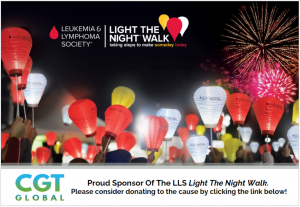 Illuminated red, white, and gold lanterns are held by participants at the Light the Night Walk, sponsored by CGT Global, with fireworks lighting up the night sky.