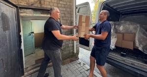 Two individuals unloading a truck and carrying boxes into a hospital in Ukraine, September 2024.