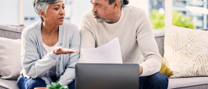 Customers trying to figure out what they should be asking an agent ( A mature couple having a conversation in front of an open laptop.)