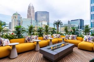 The VIP area at Merchant & Trade offers a luxurious outdoor retreat with lush greenery and a central fire pit for a warm and welcoming ambiance, all set against the backdrop of Charlotte’s skyline.