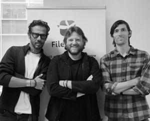 Massimiliano Maggi, Valerio Pastore (Cyber Grant Founders), and Stephen Akridge (CEO) standing with arms crossed in front of a Filegrant banner, one of the cybersecurity products developed by the American company.