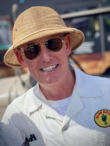 Photo of Michael Emery with pith helmet and whiet short with slow baja cactus logo.