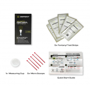 Exploded view of DEFENT Fentanyl Test Strip Kit contents. Black product box with yellow accents on left. Top right shows 5 sealed test strip packets. Bottom left displays a small white measuring cup and 5 red micro scoops. Bottom right features a Quick St