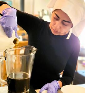 Sister Camilla pouring oil for salve making