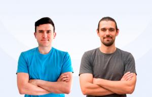 Two latino men smile into the camera with their arms crossed in front of them