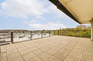 A concrete balcony overlooking a scenic waterfront with boats anchored below.