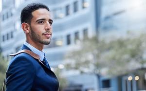 Man with a beard wearing a suit, looking into the distance