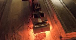 SpaceFactory's apparatus inside a lunar environment chamber, heating regolith-based material to create a durable road surface under simulated moon conditions, demonstrating advanced in-situ construction techniques.