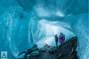 adults hiking through an ice cave and having a conversation in Iceland