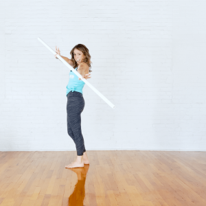 Woman who trains athletes to gain more mobility holding a mobility stick