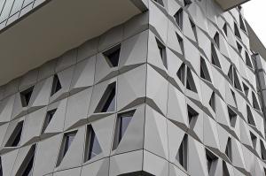 Elevation view of Malachowsky Hall at the University of Florida, highlighting the dynamic shadows and undulating effect created by the volumetric design of aluminum panels.