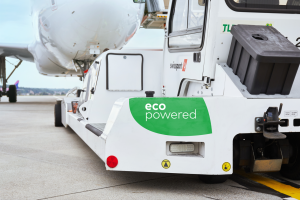 Image of a SwissPort eco-powered vehicle near an airplane on a runway.