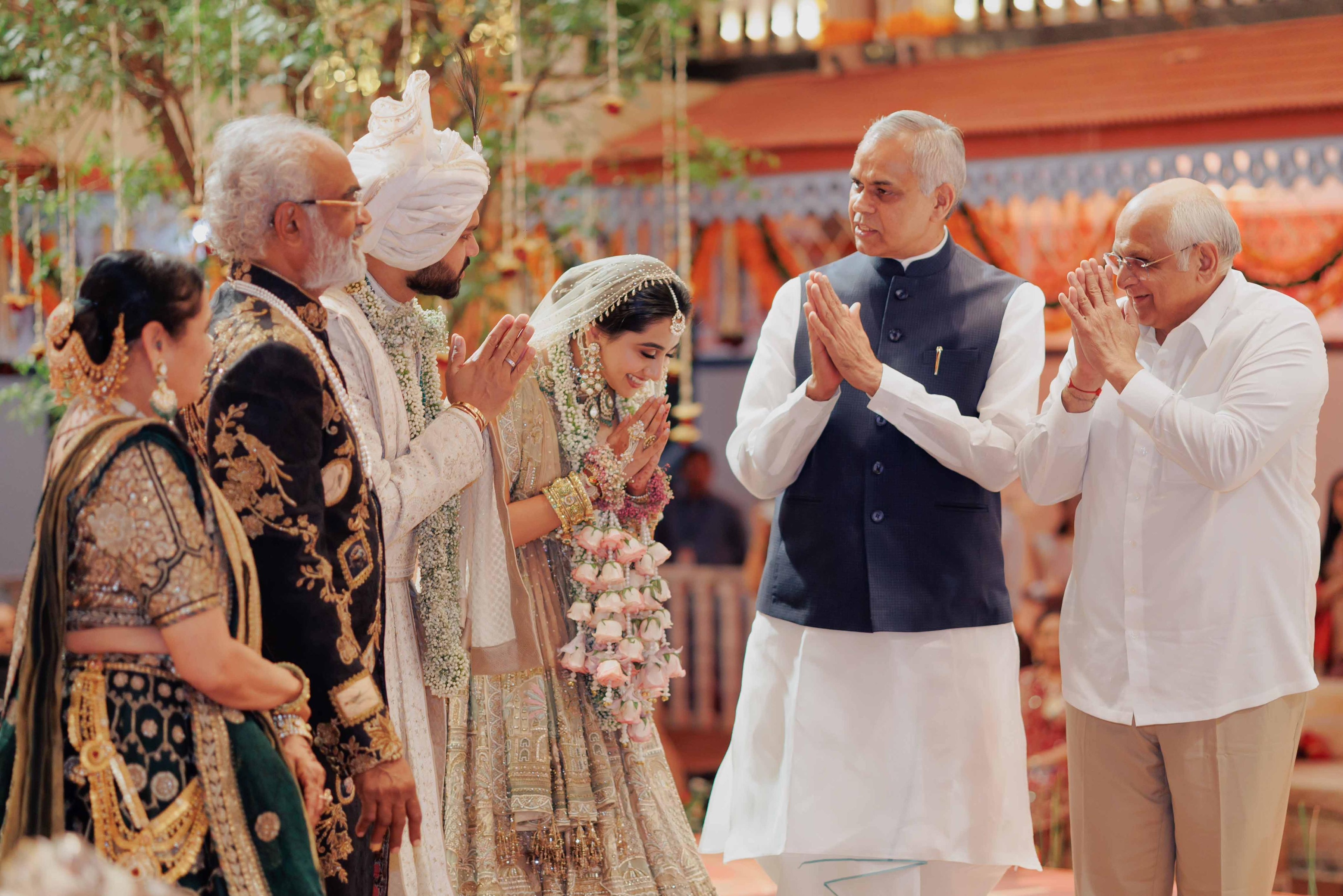 The newlywed couple, Dravya and Jahnvi, humbly seek blessings from Hon’ble Chief Minister Shri Bhupendrabhai Patel and His Majesty Acharya Devvrat Ji, adding grace and tradition to the auspicious celebration.