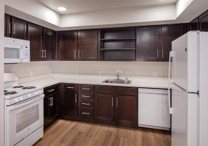 a kitchen with brown cabinets, white counters, and stainless steel appliances