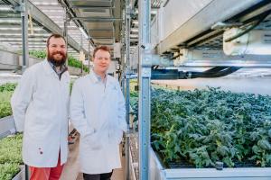 Phytoform founders Nicolas Kral and Will Pelton stand next to a tray of miniature, precision-bred tomato plants