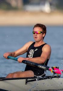 Male rowing in water with black and white tank, SD logo