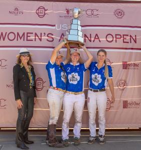 three female arena polo players lift the silver cup of the Women's Arena Open polo championship