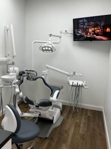 A photo of the dentist chair, their is a TV in the room