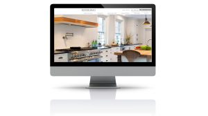 A desktop computer shows a website with the main image of a modern kitchen.