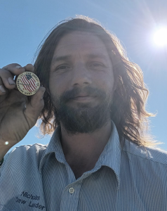 Nicholas Patterson holds Great US Treasure Hunt coin, found under a bleacher seat at Cargill Park in Shreveport, LA