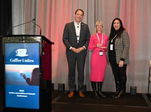 Roxanne Joyal, Founder and CEO of &BACK COFFEE, on stage receiving the Coffee Association of Canada’s Innovative Achievement of the Year Award from Robert Carter, President of the Coffee Association of Canada and Solange Ackrill, Vice Chair of Coffee Asso