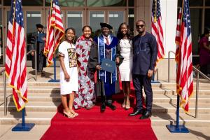 A graduate from California Intercontinental University and his family at the entrance of the 2024 commencement ceremony at the Richard Nixon Library.