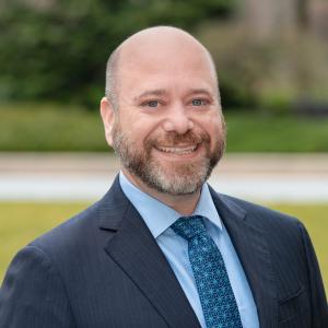 Matt Contento, a white man in business attire, smiles for the camera