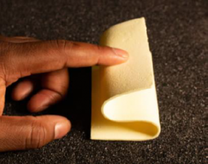 An engineer presses down on a sample of a compliant foam.infused with new 'dream material' aerogel, which flexes in response to being pressed.