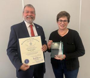 Randi Sargent and Carmine Gentile hold certification of appreciation for recognition for manufacturing innovation of assistive devices.