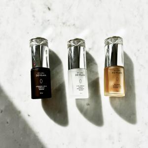 Image showcasing Dr. Devgan Scientific Beauty's next-generation serum superheroes: Vitamin C+B+E Ferulic Serum, Retinal Bakuchiol Serum 5x, and Hyaluronic Niacin Panthenol Serum, each elegantly displayed against cool-toned white marble.