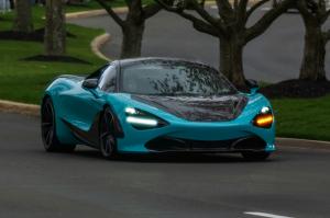 A turquoise McLaren driving on a paved road, representing Veritas Global Protection's focus on safeguarding exotic vehicles.