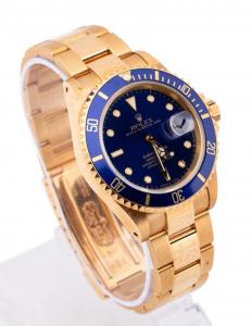 Rolex Oyster Perpetual Submariner date wristwatch in 18k yellow gold, with blue dial, white markers, date window, synthetic sapphire crystal with cyclops window (est. $26,000-$29,000).