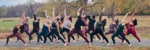 A group of people doing yoga outside