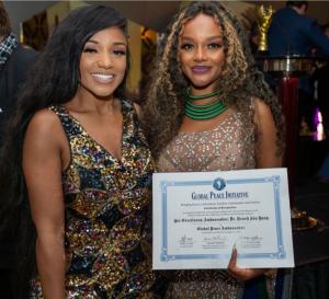 Dr. Natasha Weems, DNP. AGPCNP-BC with Queennak.  Dr. K.A. Paul honors Queen Nak (Dr. Neneh Ada Yang) with the Global Peace Ambassador Certificate for her dedication to social justice, global empowerment, and Peace Initiative. Photographer: Montez Harris