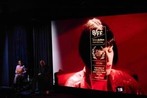 Fashion film screening in a cinema featuring a woman in red.