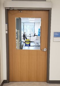 A right facing wooden automatic door with a window