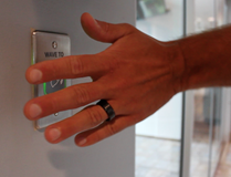 A man waving his hand against a sensor to open an automatic door