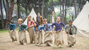 several elementary school age children compete at summer camp in a fun sack rack