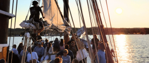 People on a sailboat enjoying a sunset cruise on calm waters.