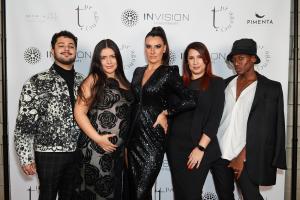 Photography of 5 people wearing black and white gala outfits. they are standing in front of a white banner with tpr agency and invision investments logos.