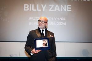 Billy Zane holding up a photo of Marlon Brando who he portrays in "Waltzing with Brando" at the 42nd Torino Film Festival