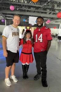 Michael King, MLB pitcher for San Diego Padres; Lisa Yob, Director of Philanthropy - Yob Family Foundation; and Chris Godwin, NFL All-Star wide receiver for Tampa Bay Buccaneers, celebrate the holiday spirit at the Yob Family Foundation’s Christmas Event at ZooTampa.