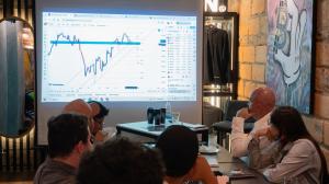 A group of attentive attendees watches a presentation on stock indexes projected on a screen during EBC’s LATAM Traders’ Exchange - EBC