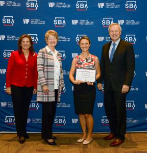 Melissa Albanes, COO of Valyr, stands on stage with VIP leadership holding the VIP START Certification award.