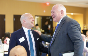 Andy Kovacs, President of Moments of Truth Insurance Services and Breakfast Series Sponsor, smiling and sharing a light moment with Markham Mayor Frank Scarpitti during the Markham Board of Trade Breakfast Networking event. Both are dressed in business at