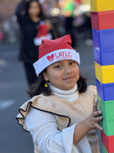 A child celebrating with her family at the ninth annual Los Angeles Trial Lawyers' Charities "Comfort & Joy" event