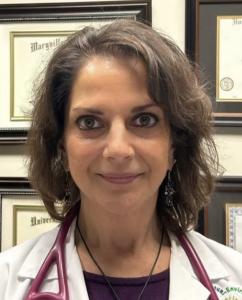 Dr. Cipriano in her office in front of her diplomas and certifications
