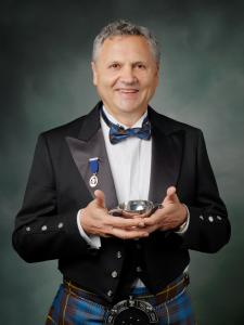 An image of a man in Scottish dress holding a quaich in his hands