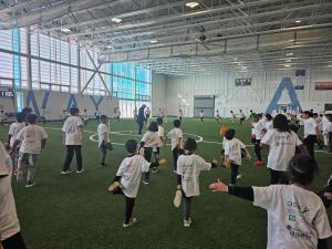 A group of children participating in warm-up drills during the opening session of the OSCA 2025 Winter Semester Brampton Recreational Cricket Program, engaging in active living and teamwork.